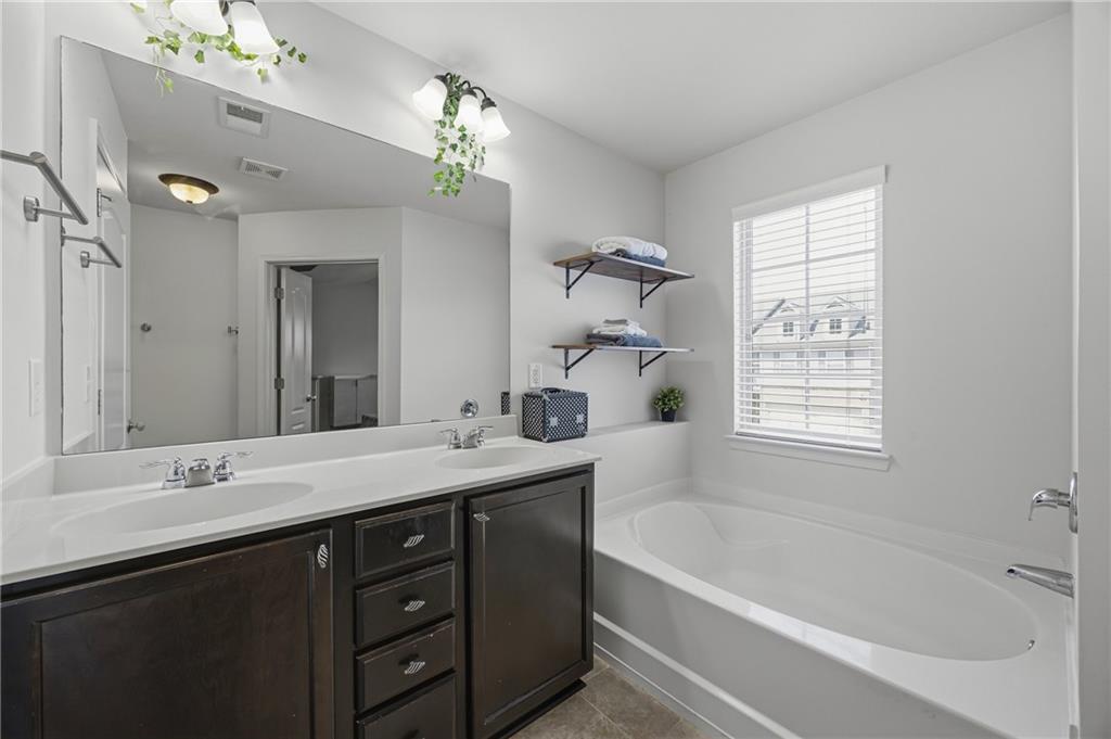 4021 Princeton Lakes Pass Southwest Atlanta, GA 30331 - Photo 19 of 23 a bathroom with a tub a sink and mirror