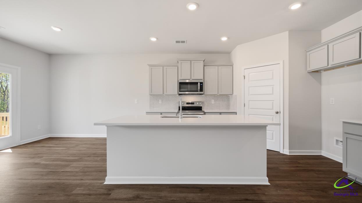 227 Cattle Drive Perry, GA 31069 - Photo 8 of 40 a kitchen with stainless steel appliances a sink a stove a refrigerator and cabinets