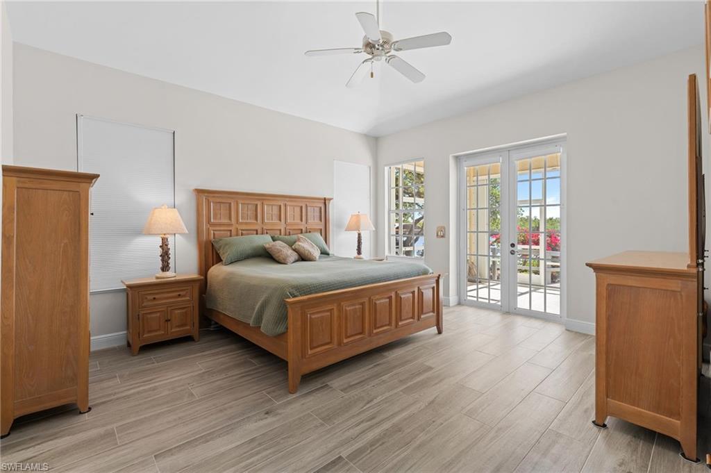 132 Wilderness Cay Naples, FL 34114 - Photo 11 of 24 a bedroom with a large bed and a chandelier