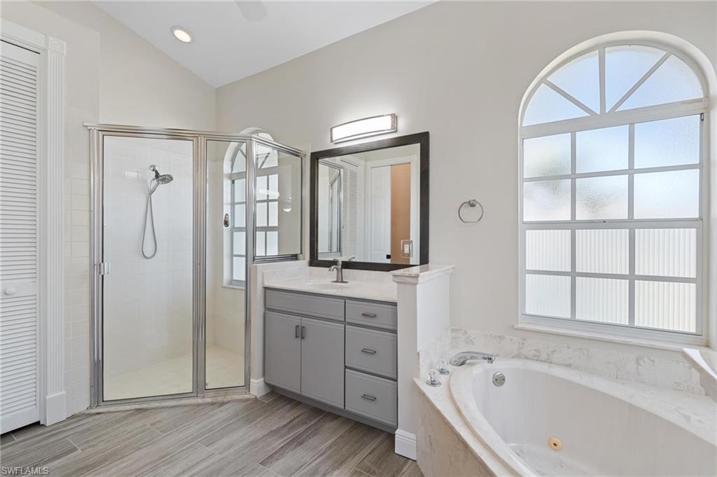 132 Wilderness Cay Naples, FL 34114 - Photo 14 of 24 a bathroom with a tub sink and mirror