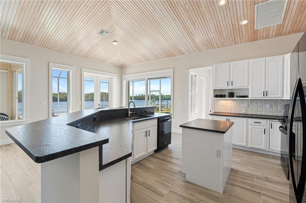 132 Wilderness Cay Naples, FL 34114 - Photo 10 of 24 a kitchen with stainless steel appliances granite countertop a sink a stove and white cabinets