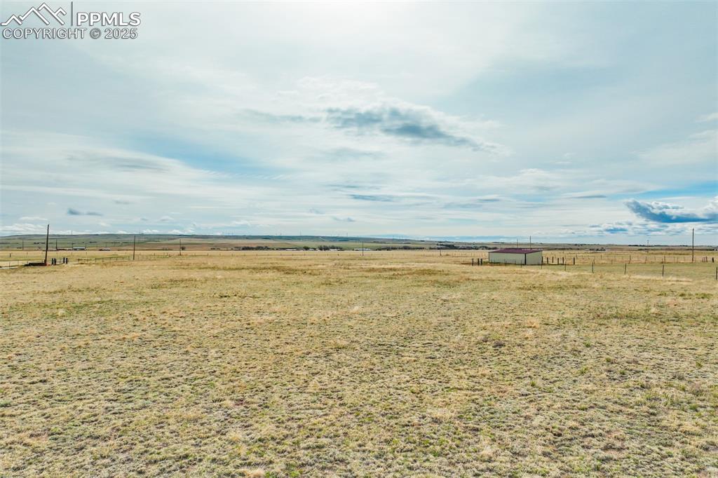 10165 McClelland Road Calhan, CO 80808 - Photo 6 of 25 View of yard with an outdoor structure, fence, and a rural view