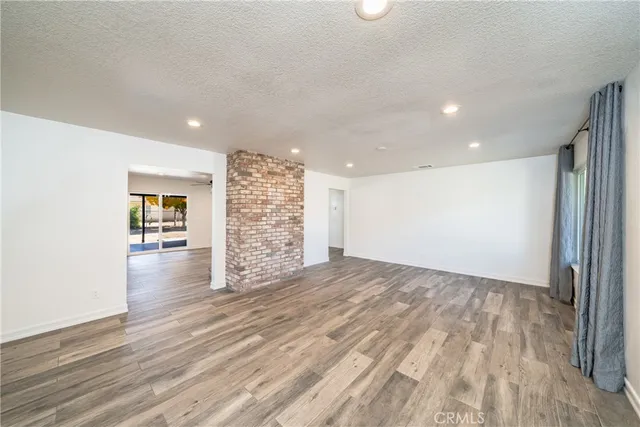 a view of empty room with wooden floor and window