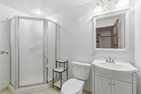 a bathroom with a toilet a sink a mirror a vanity and window