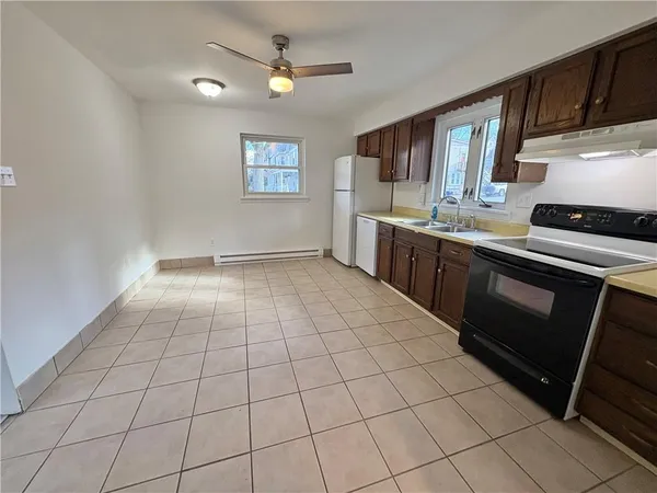 a large kitchen with granite countertop a stove a sink dishwasher and a refrigerator