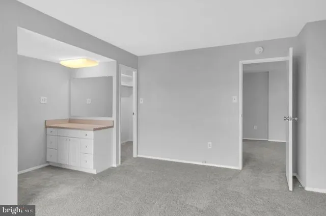 an empty room with sink and mirror