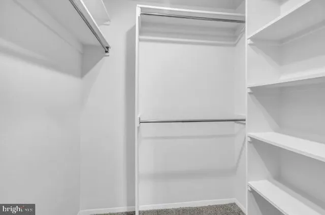 a view of walk in closet with empty racks