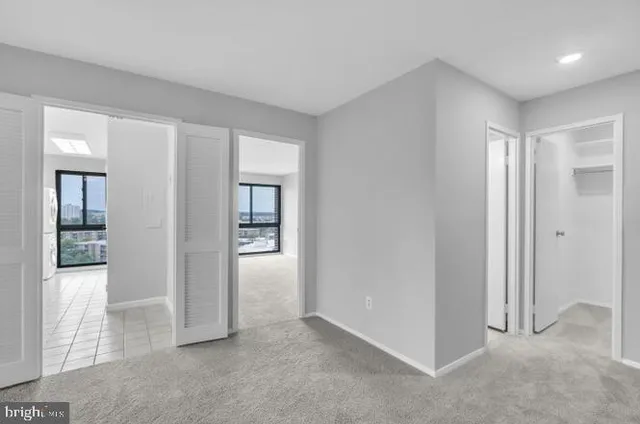 an empty room with windows and closet