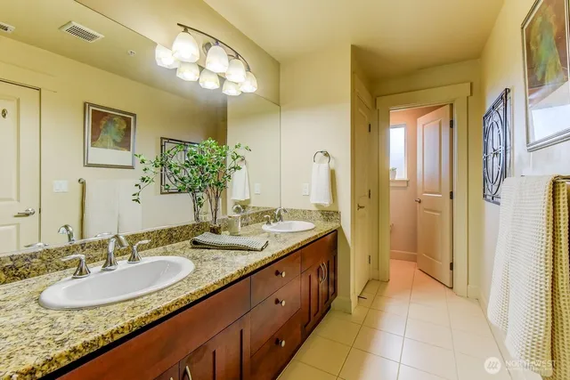 a spacious bathroom with a granite countertop sink and a mirror