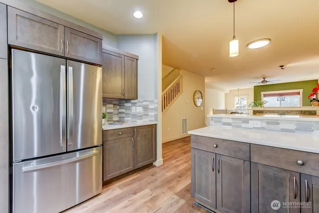 a kitchen with stainless steel appliances granite countertop a refrigerator a sink and a refrigerator