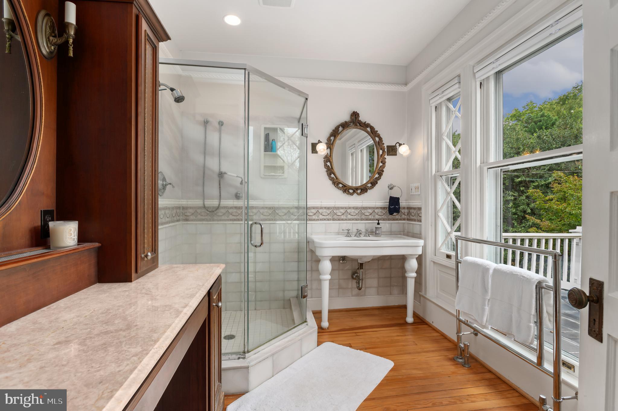 6515 Brookville Road Chevy Chase, MD 20815 - Photo 16 of 33 a bathroom with a granite countertop sink a mirror and a shower