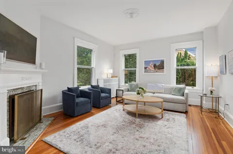 a living room with furniture a flat screen tv and a fireplace