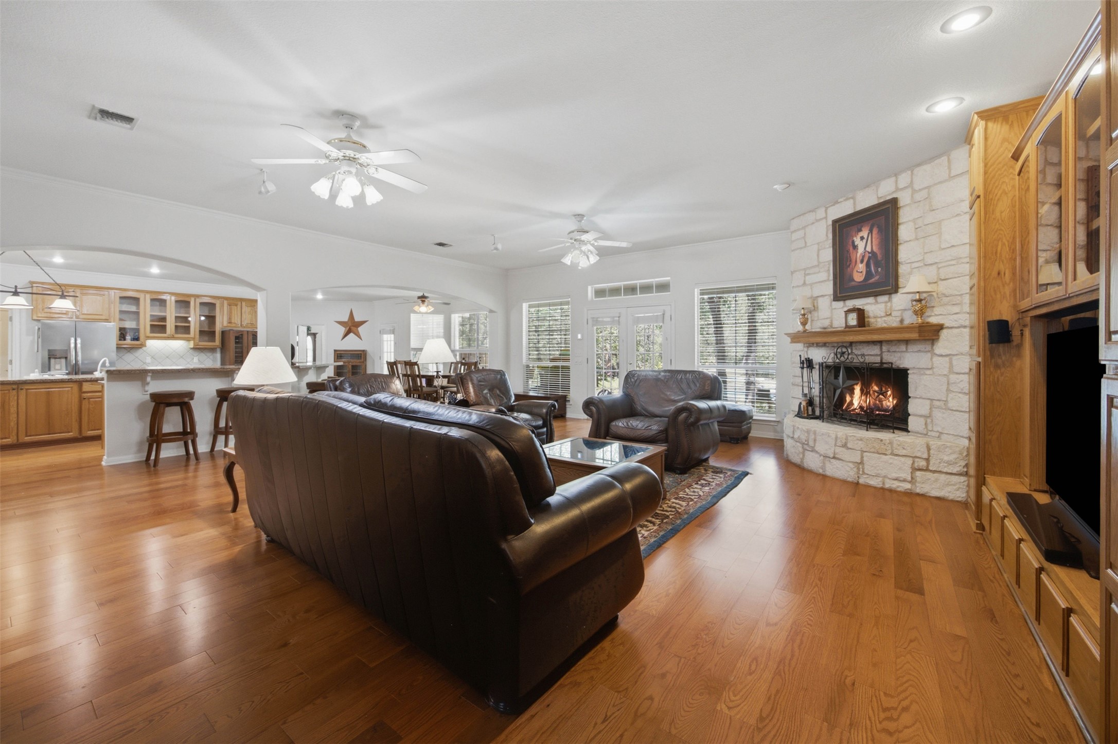 197 Elm Wood Drive Elgin, TX 78621 - Photo 5 of 37 Natural wood flooring complements the rustic stone fireplace and inviting living area.