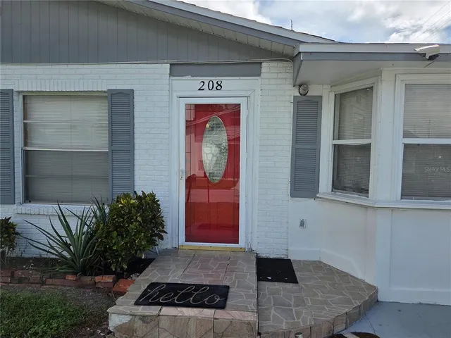 a front view of a house with a yard and a garden