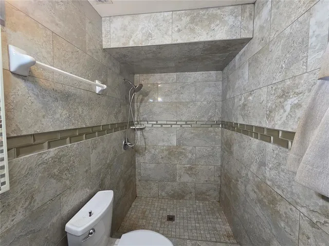 a bathroom with a toilet and a shower
