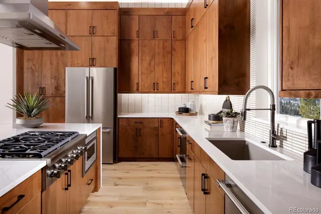 a kitchen with stainless steel appliances granite countertop a sink stove and refrigerator
