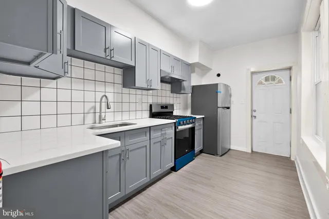 a kitchen with a sink a refrigerator and cabinets