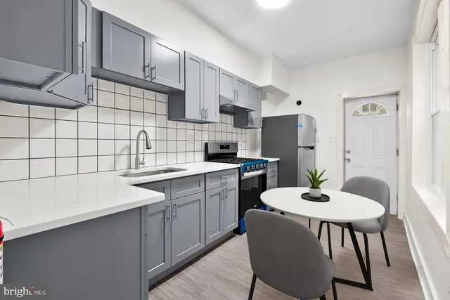 a kitchen with a dining table chairs sink and cabinets
