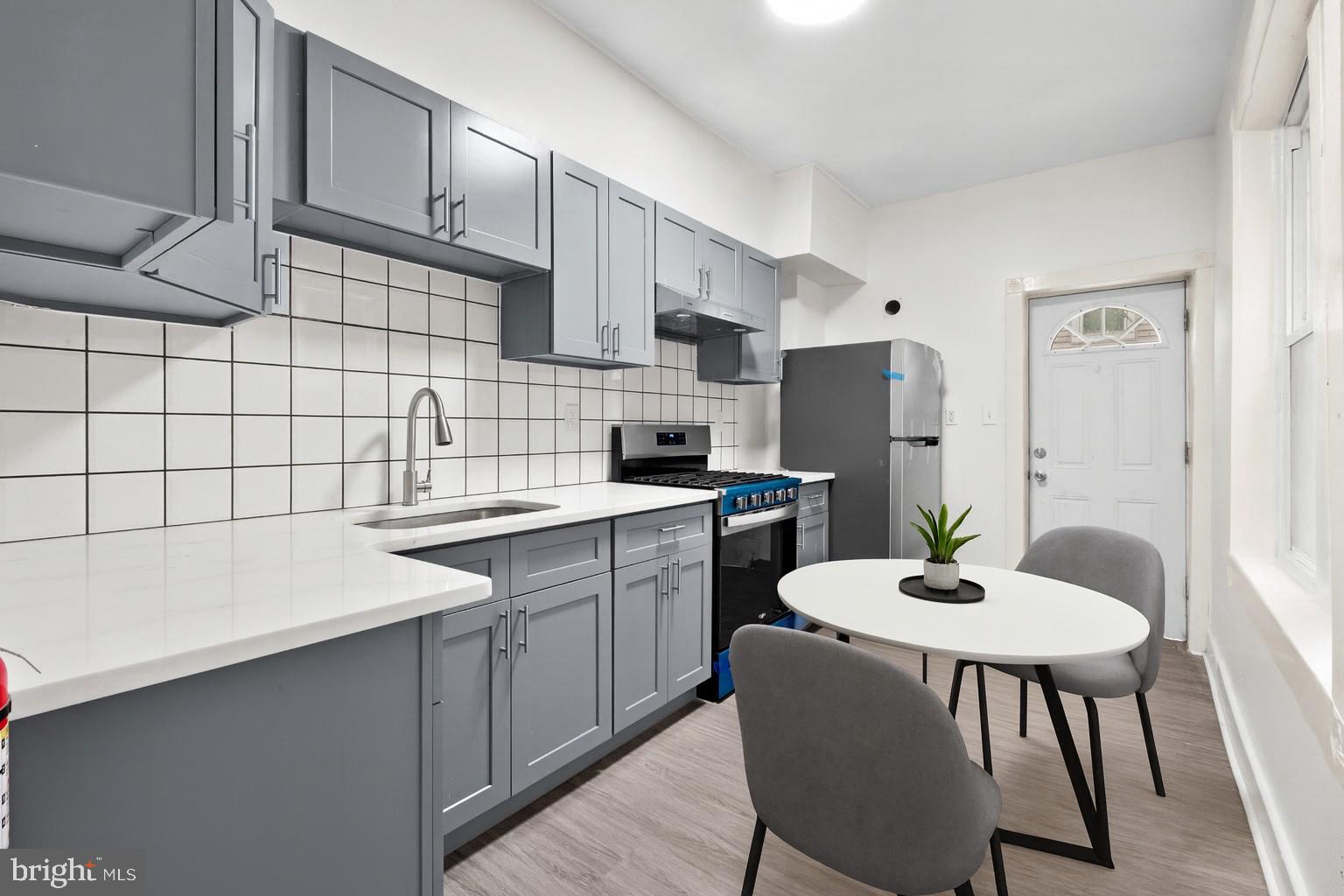 344 Middlesex Street Gloucester City, NJ 08030 - Photo 15 of 25 a kitchen with a dining table chairs sink and cabinets