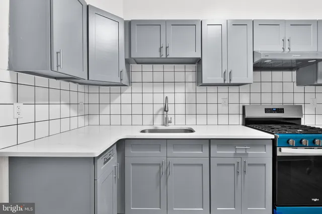 a kitchen with stainless steel appliances granite countertop a sink stove and cabinets