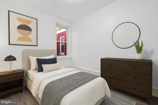 a bedroom with a bed and a painting on the wall