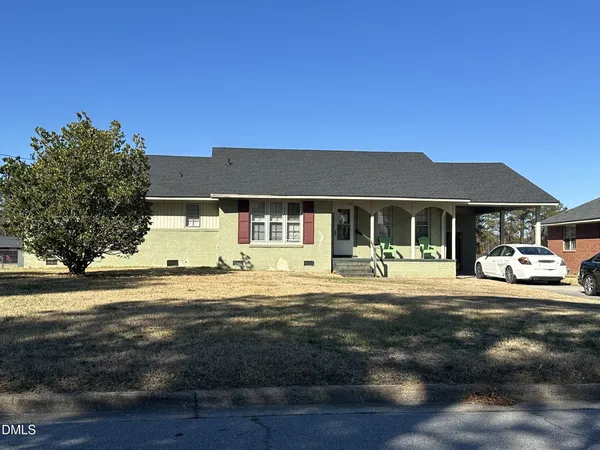 a front view of a house with a garden and patio