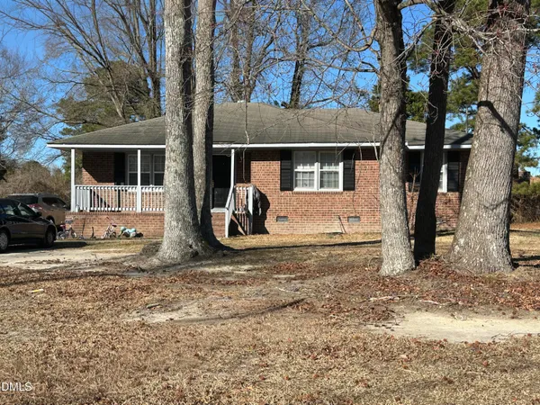 a view of a house with a yard tree and a front door
