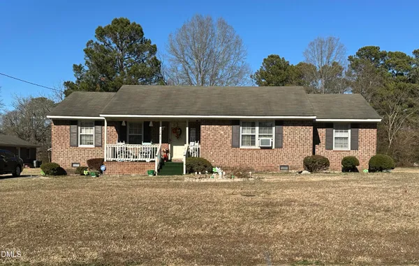 a front view of a house with large garden