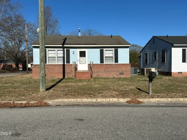 a view of a house with a yard and large tree