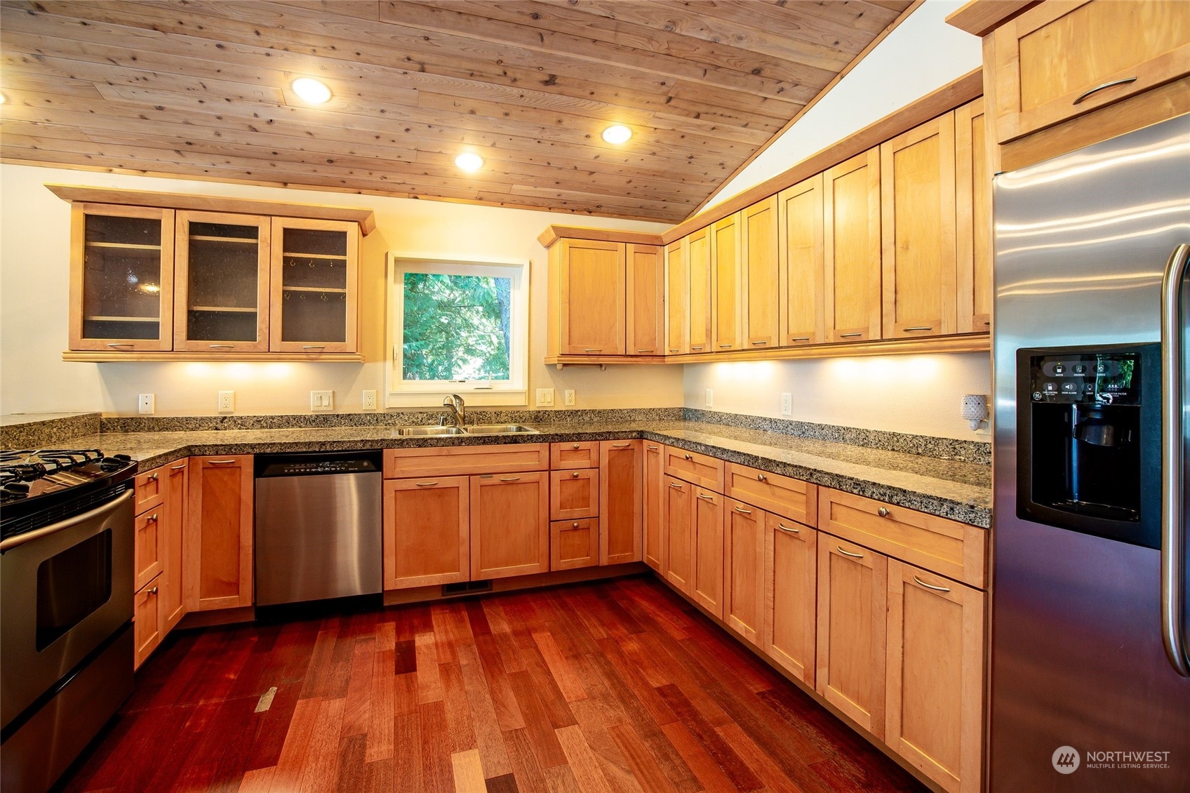 63 Point Caution Drive Friday Harbor, WA 98250 - Photo 11 of 30 a kitchen with stainless steel appliances granite countertop wooden cabinets a stove top oven a sink and dishwasher with wooden floor