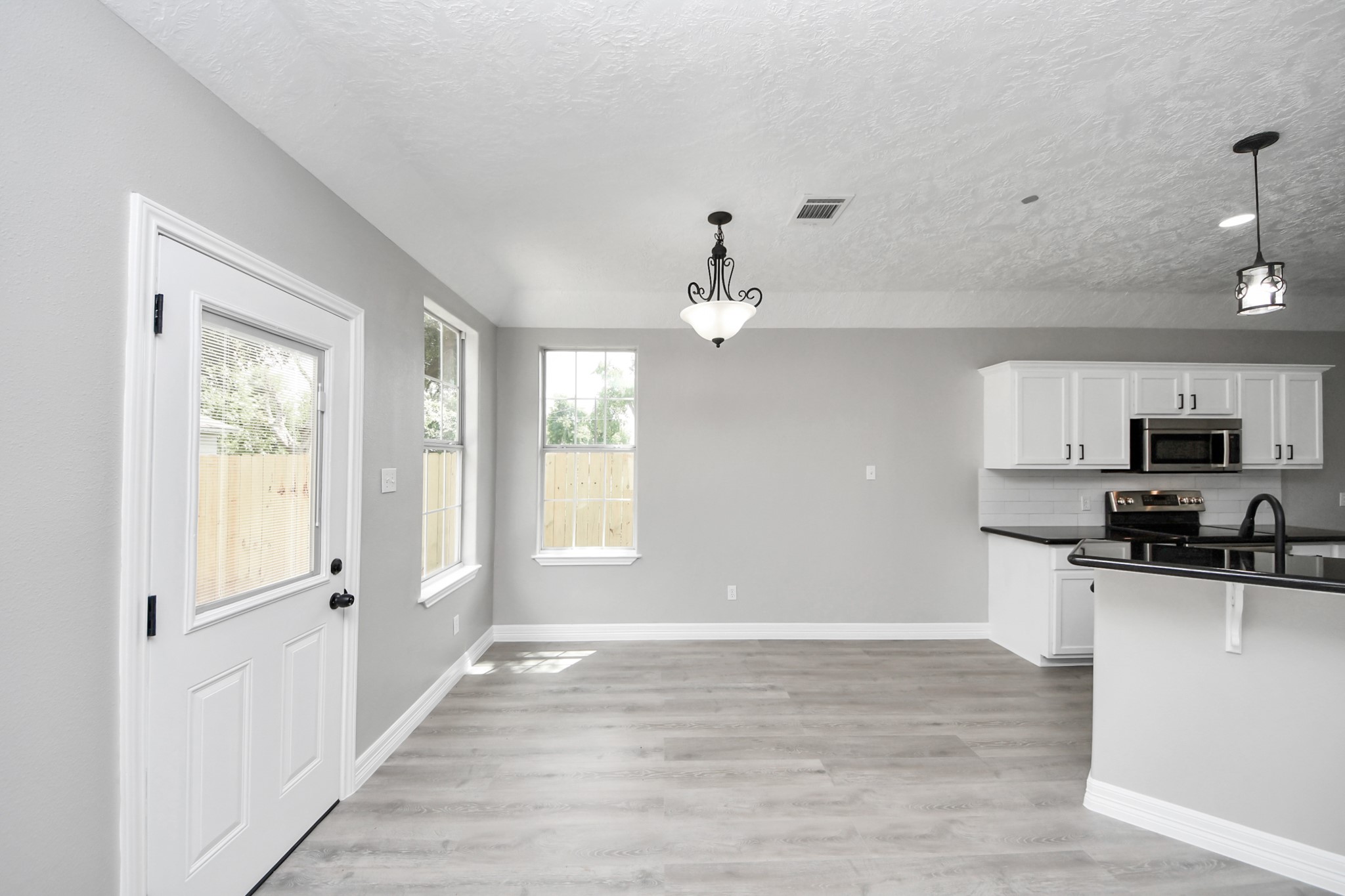 1105 East Kyle Road Clute, TX 77531 - Photo 7 of 44 The dining area features two large windows and a door leading to the backyard, offering ample natural light.
