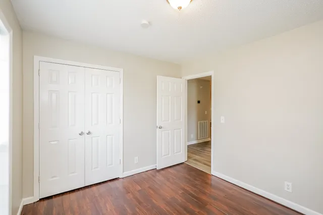 an empty room with wooden floor and closet