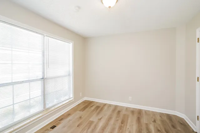 wooden floor in an empty room with a window