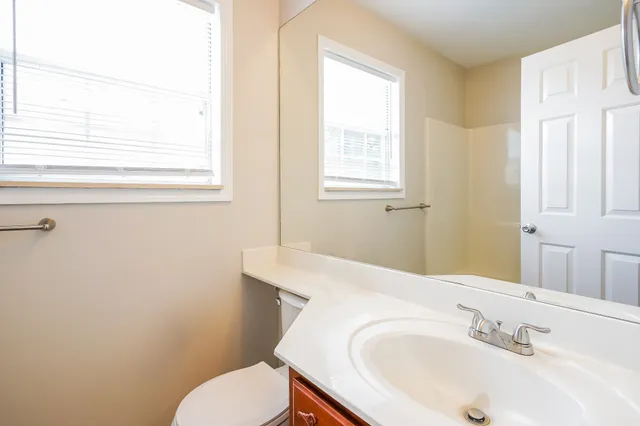 a bathroom with a sink a toilet and a window