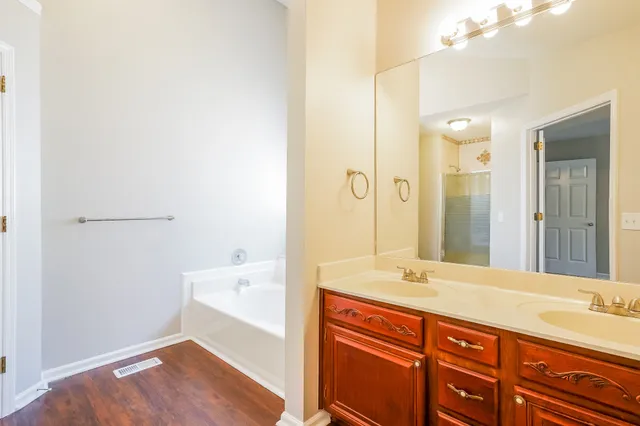 a bathroom with a tub sink and mirror