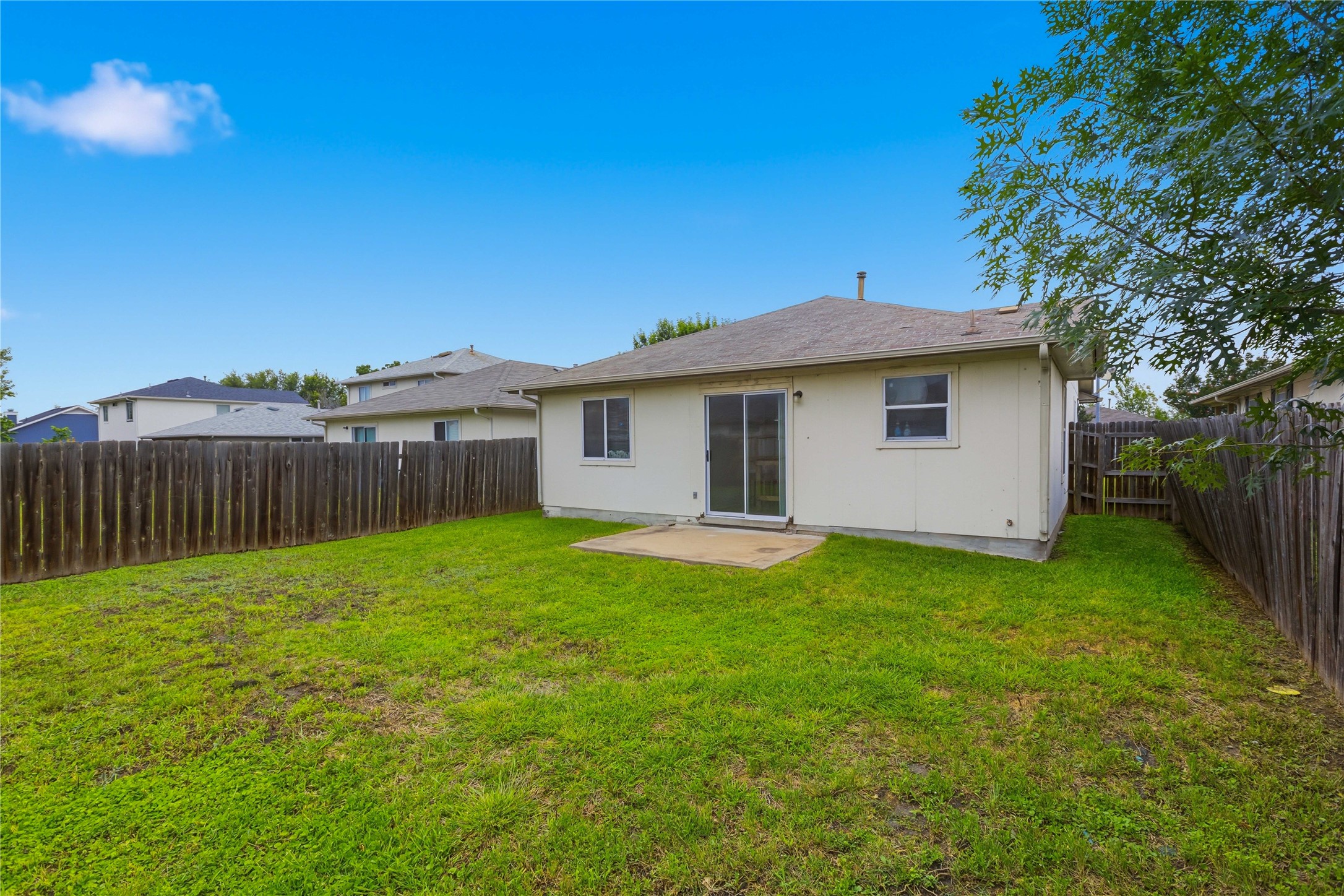 16112 Hamilton Point Circle Manor, TX 78653 - Photo 26 of 27 Expansive backyard featuring a concrete patio, sliding glass door, and full privacy fencing
