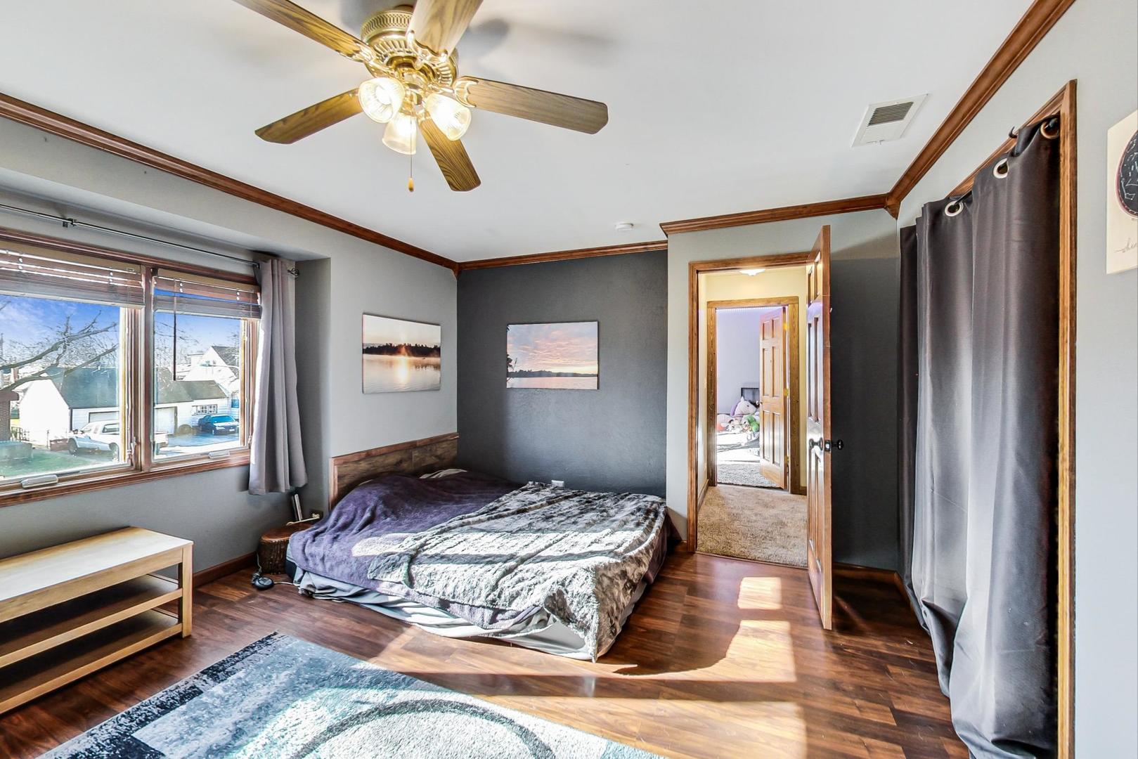 3616 West 116th Street Chicago, IL 60655 - Photo 13 of 33 a bedroom with a large bed and a chandelier