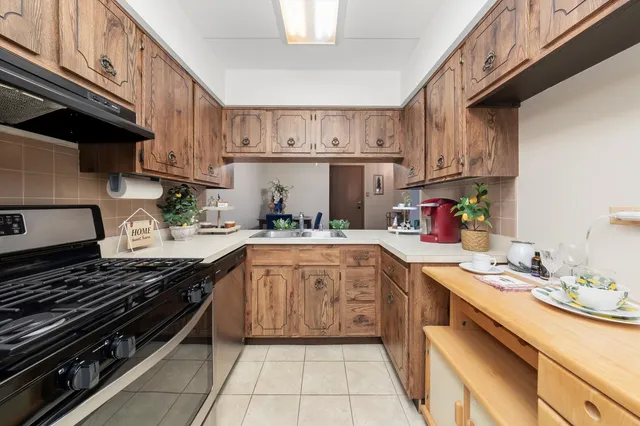 a kitchen with kitchen island granite countertop a sink stove and cabinets