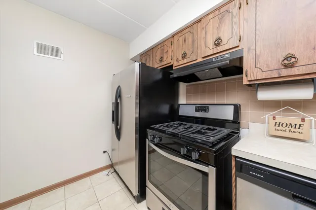 a kitchen with granite countertop a stove and a refrigerator