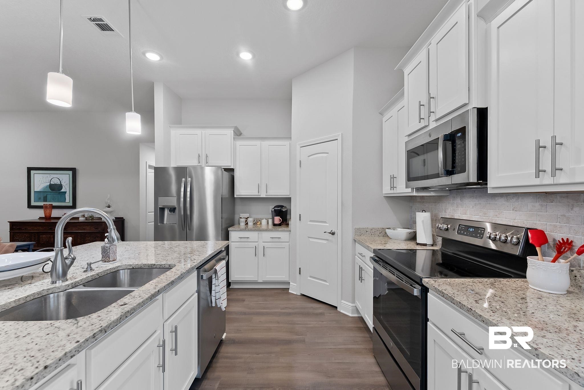 32868 Arbor Ridge Circle Lillian, AL 36549 - Photo 13 of 35 Kitchen with stainless steel appliances, white cabinetry, light stone counters, and dark wood finished floors