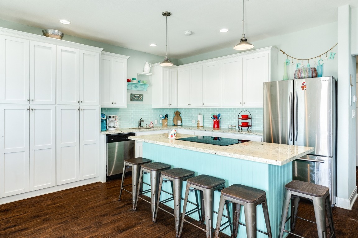 510 Point Lookout Surfside Beach, TX 77541 - Photo 7 of 41 a kitchen with stainless steel appliances granite countertop a sink a stove a refrigerator and white cabinets with wooden floor
