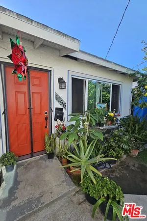 a vase of flowers sitting in front of a house