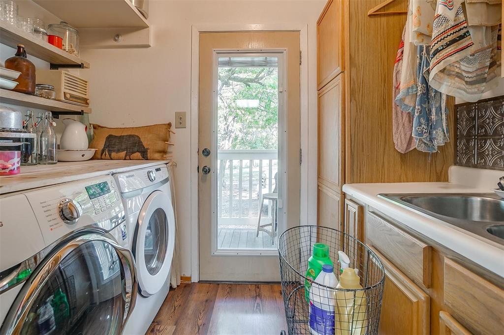 8716 County Road 1224A Rio Vista, TX 76093 - Photo 30 of 38 Laundry room with washing machine and clothes dryer and dark wood-style flooring