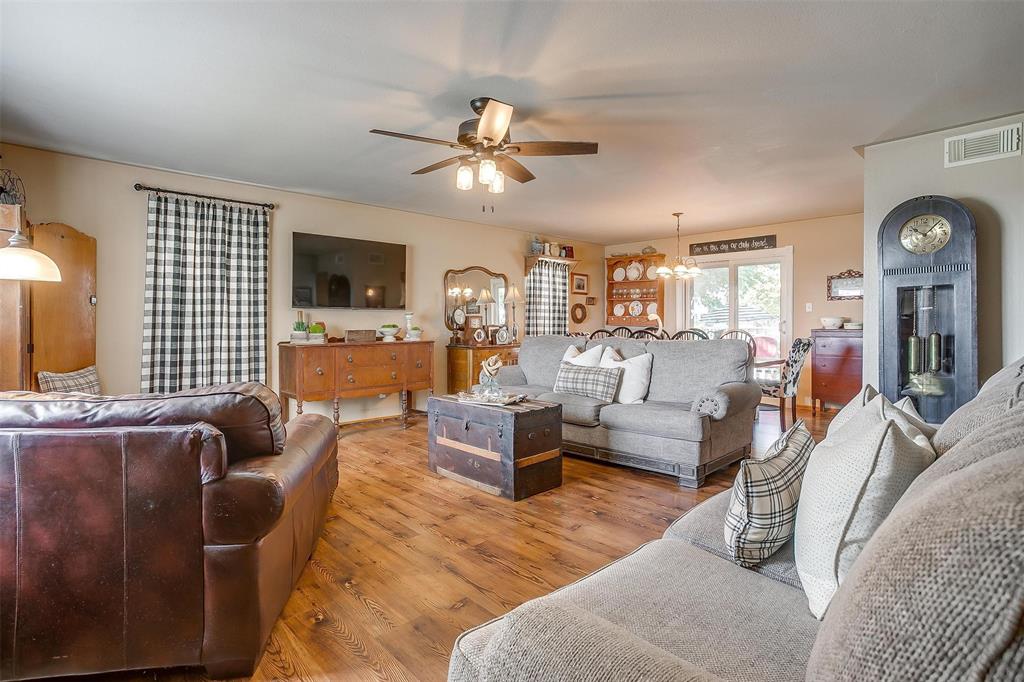 8716 County Road 1224A Rio Vista, TX 76093 - Photo 31 of 38 Living area with a chandelier, wood finished floors, and ceiling fan