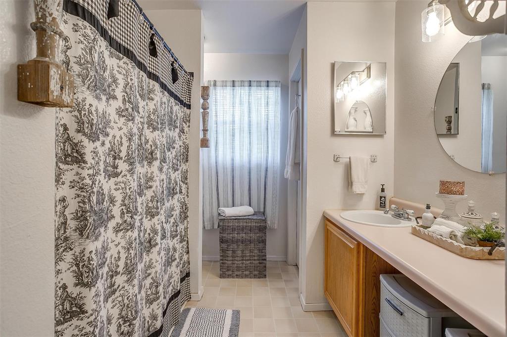 8716 County Road 1224A Rio Vista, TX 76093 - Photo 34 of 38 Bathroom featuring vanity, light tile patterned floors, and a shower with curtain