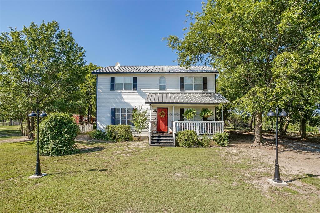 8716 County Road 1224A Rio Vista, TX 76093 - Photo 5 of 38 View of front of home with covered porch, a metal roof, and a front yard