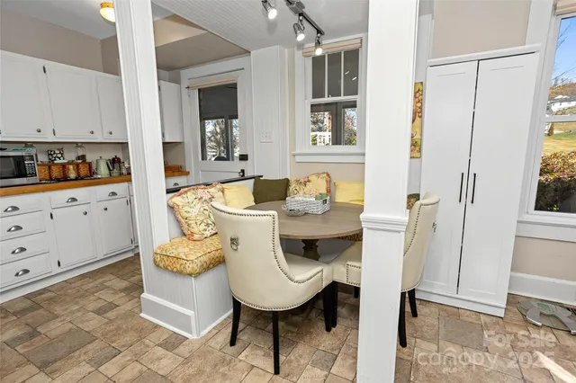 a living room with stainless steel appliances furniture a rug and a window
