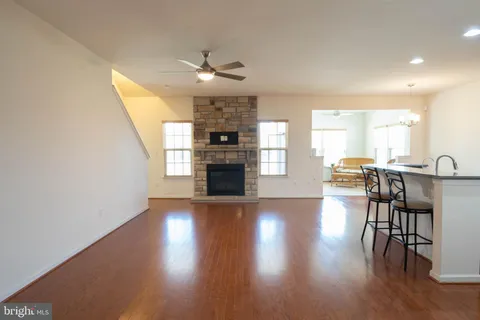 a view of a livingroom with furniture a fireplace wooden floor and chandelier