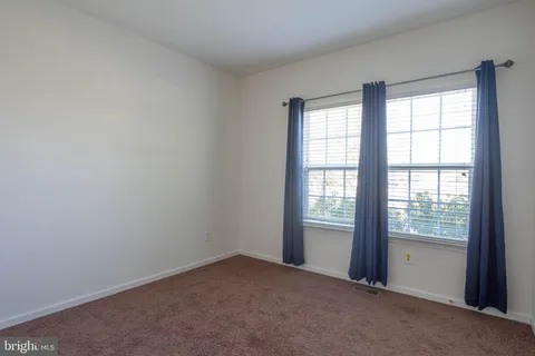 an empty room with a window and a ceiling fan