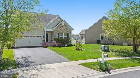 a front view of a house with a yard and trees